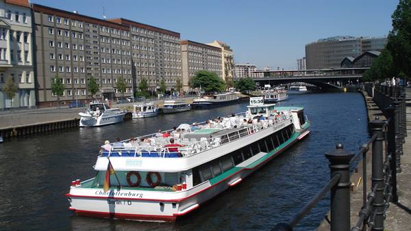 Tour boat Charlottenburg cruising the Spree river in Berlin past buildings and a bridge