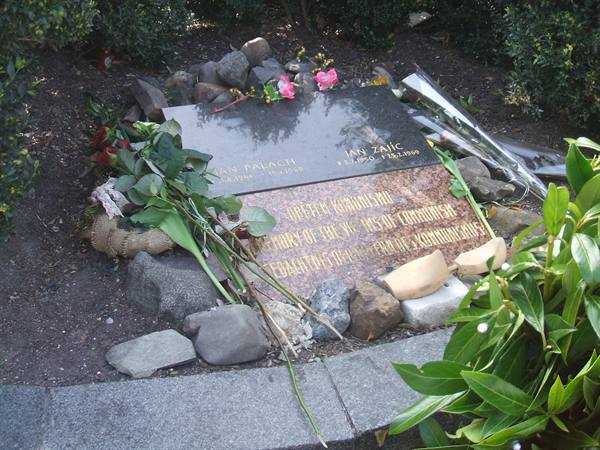 Jan Palach granite memorial plaque covered with flowers and stones