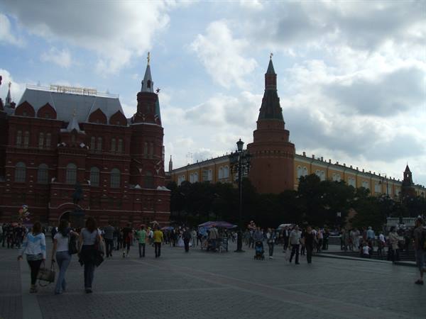 Tourists walk across Moscow's Red Square between the Historical Museum and Kremlin towers