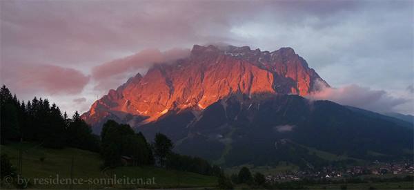 the peak of Zugspitze turning pink at sunset