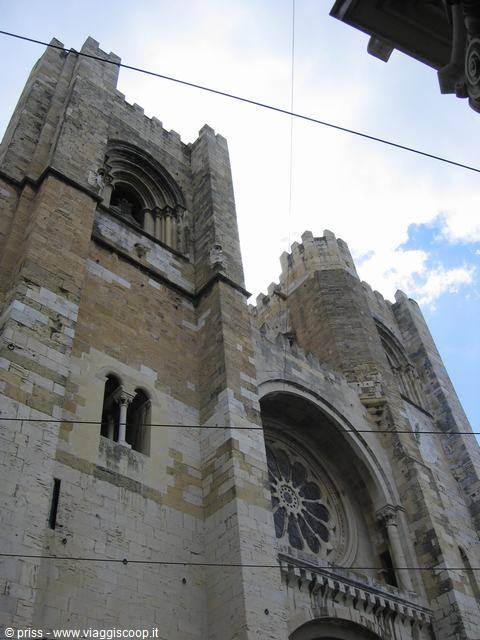 Fortified stone facade of Lisbon Cathedral, rose window and crenellated towers