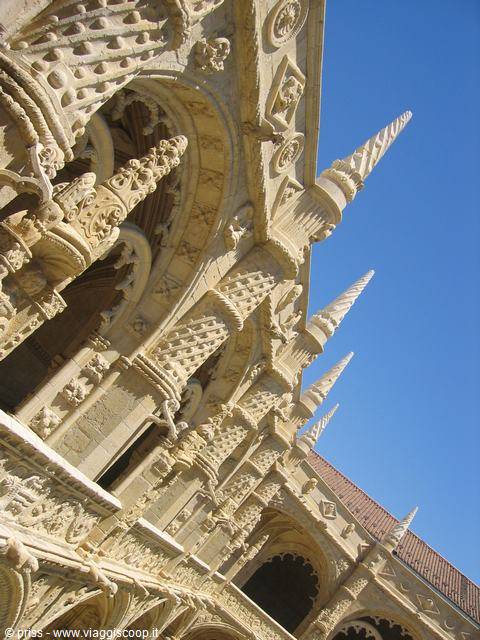 Manueline cloister of the Jerónimos Monastery in Lisbon, limestone spires against blue sky