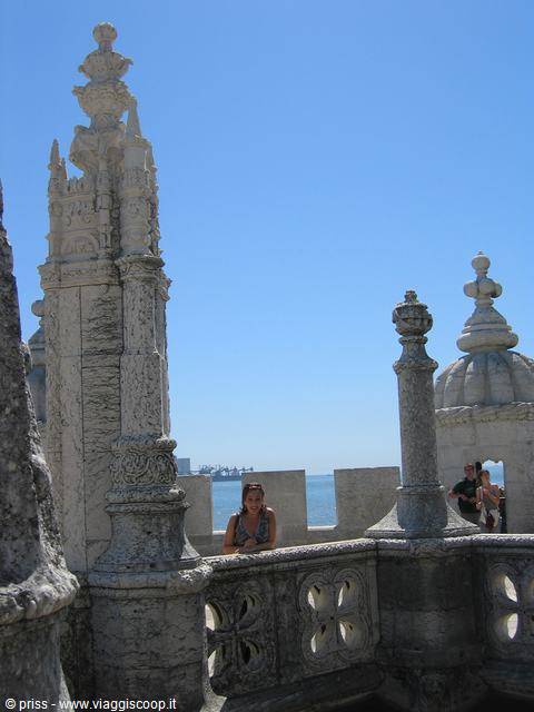 Tourist on the Belém Tower terrace, carved stone and sea in the background