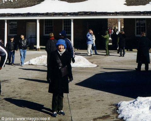 Woman in blue hat smiling before historic buildings with snow