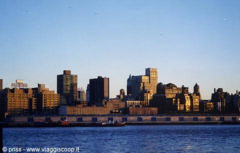 Manhattan skyscrapers over the East River, golden light on brick buildings