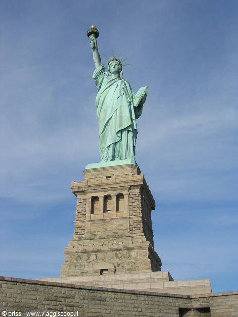 The Statue of Liberty, green oxidized copper on granite pedestal, blue sky