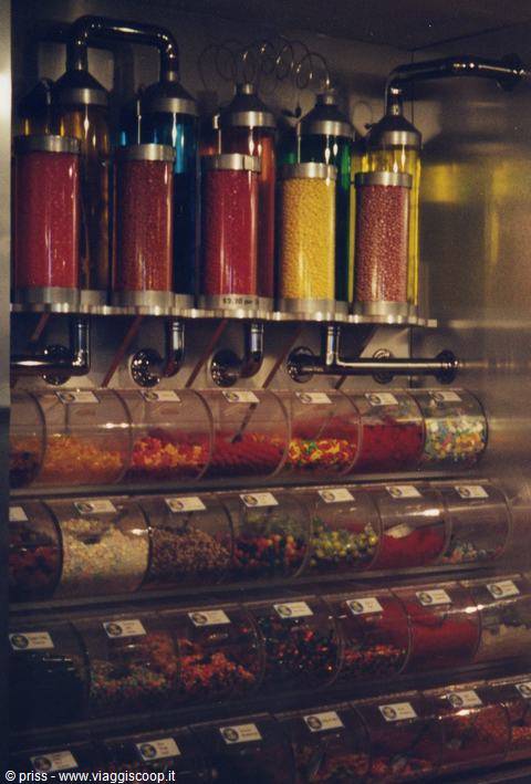 Candy dispenser with colorful glass cylinders and rotating transparent containers