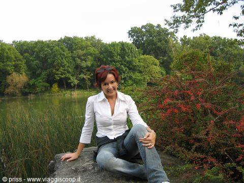Woman sitting on a rock beside the Central Park lake, New York