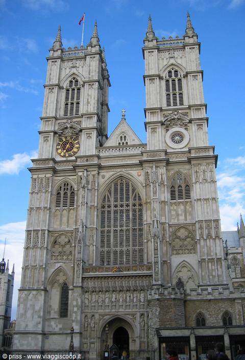 Gothic stone facade of Westminster Abbey, twin towers against blue sky