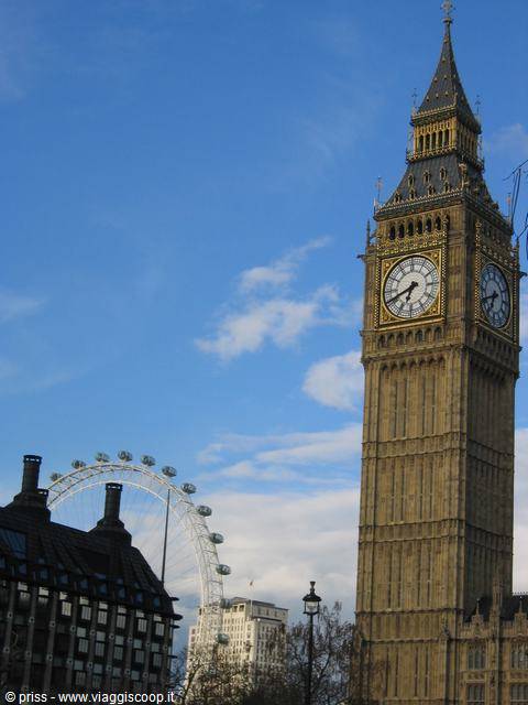 Big Ben with its golden clock beside the London Eye under a blue sky