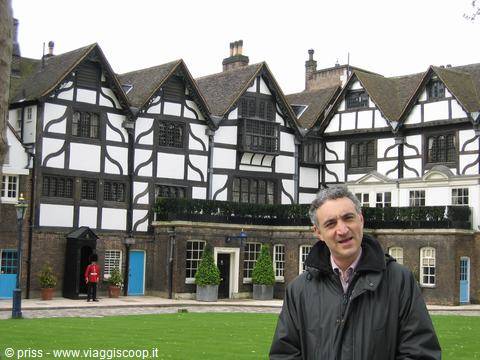 Smiling tourist in front of the Tudor houses at the Tower of London