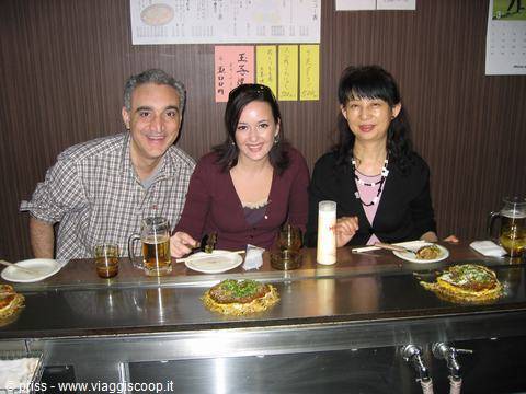 Okonomiyaki fumanti al bancone del ristorante, birre e sorrisi a Hiroshima