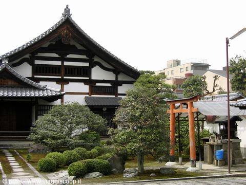 Tempio in legno e piccolo torii vermiglio nel giardino di Kyoto