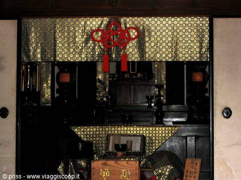 Wooden Buddhist altar with red knotted ornament, lanterns and golden cloth