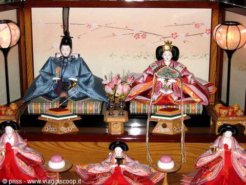 Hina Ningyo dolls in silk robes on festival altar, lit paper lanterns