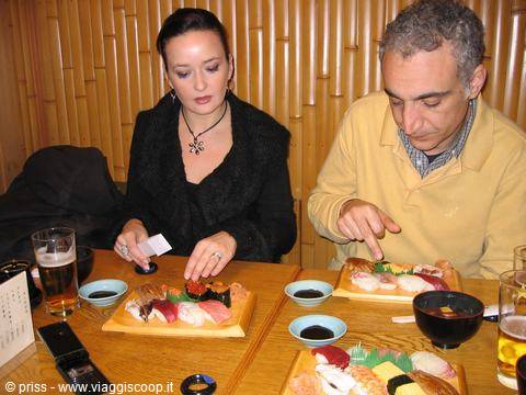 Couple eating sushi from wooden trays at a Japanese restaurant