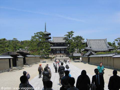 Visitors walk toward the wooden hall and pagoda of Hōryū-ji temple