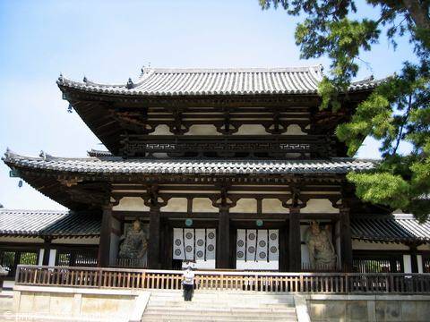 Wooden gate of Hōryū-ji temple in Nara, guardian statues and tiled roof