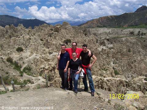 Four tourists posing among the eroded rock formations of Valle de la Luna, La Paz