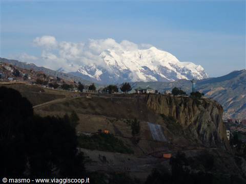 Snow-capped Illimani towers over La Paz above brown hills