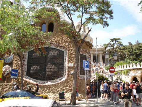 Tourists outside Gaudí's stone gatehouse at Park Güell, Barcelona
