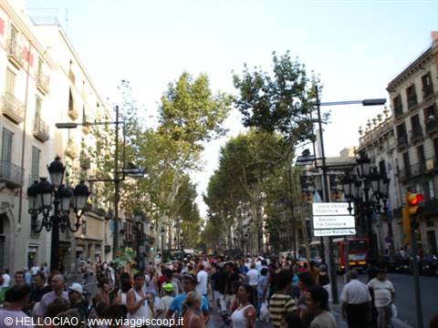 Crowds of tourists along La Rambla, trees, ornate lampposts and buildings, Barcelona