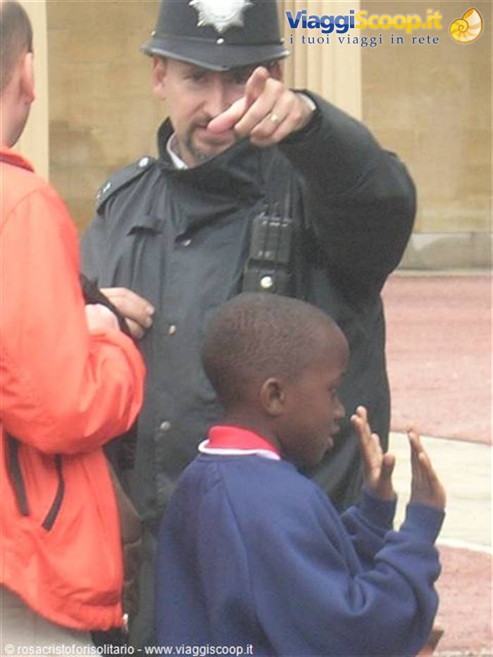 Helmeted policeman points toward a clapping boy nearby