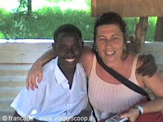 Woman and young man smiling arm in arm under a wooden shelter
