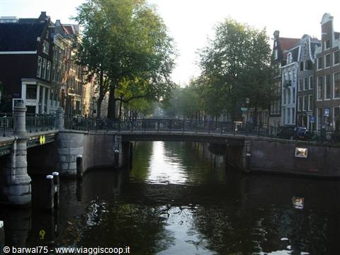 Brick bridge over Amsterdam canals, Dutch houses and golden light