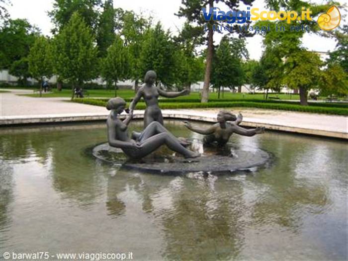 Bronze female statues bathing in a fountain pool in the park