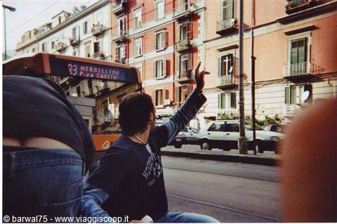Girl waving her arm near bus 93 among orange apartment buildings