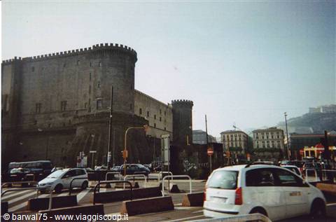 Castel Nuovo in Naples, crenellated stone towers, city traffic under clear sky