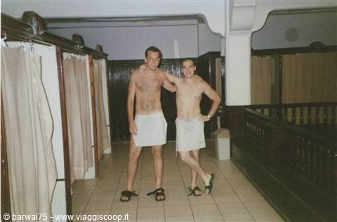 Two men in towels and sandals inside a Turkish bath