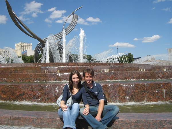 Couple sitting in front of the fountain with metal sculptures at Moscow Manege Garden