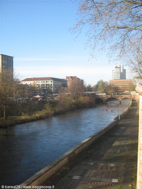 City river with stone bridge and red and yellow kayaks