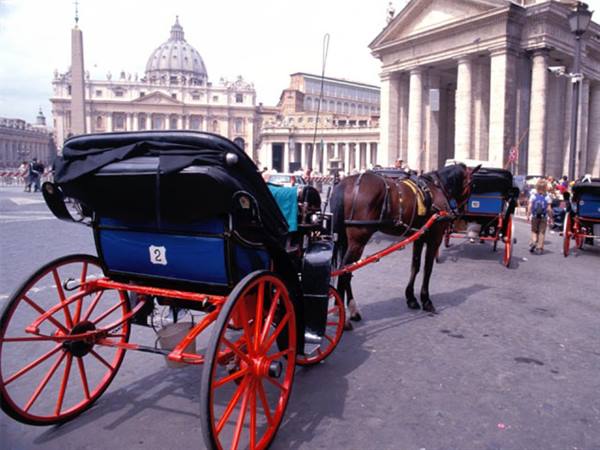 Horse-drawn carriages in St. Peter's Square, Rome, dome in background