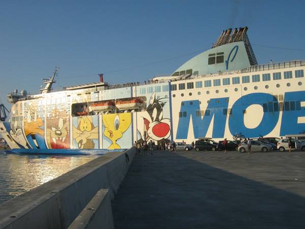 Moby ferry with Looney Tunes characters docked at port, cars boarding