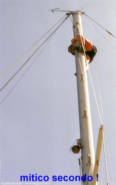 Man climbing the metal mast of a sailboat