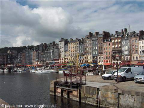 Boats moored at Honfleur harbor lined by old slate-fronted houses