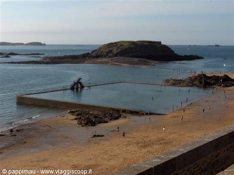 Seawater pool on Saint-Malo beach, swimmers on sand and rocks