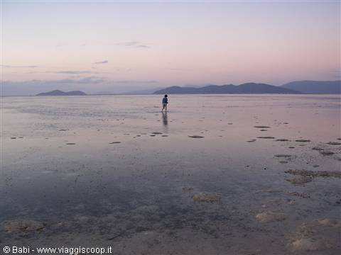 Person walking on shallow water at Wade Bridge, pink twilight sky