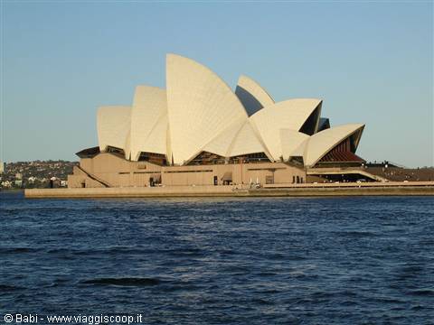 Sydney Opera House white shells glowing in sunlight, seen from the harbour water