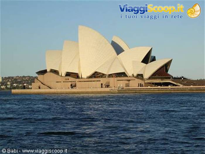 Sydney Opera House white shells glowing in sunlight, seen from the harbour water