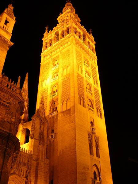 The Giralda of Seville glowing yellow against the night sky