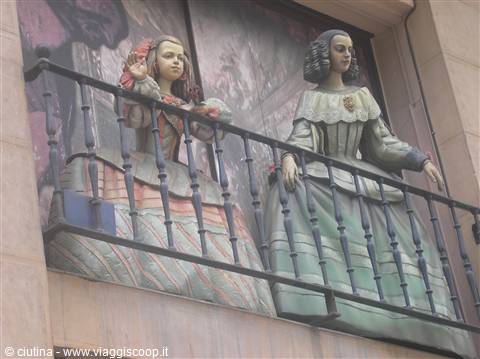 Two papier-mâché fallera figures standing on a building balcony