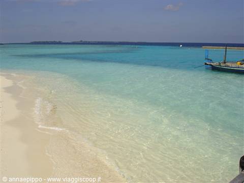 White sand and turquoise water, a boat moored near the atoll
