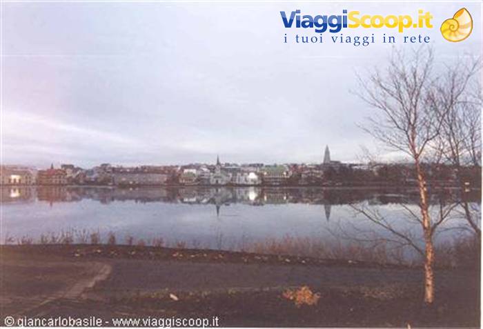 Tjörnin pond in Reykjavik, houses reflected in still water, Hallgrímskirkja tower