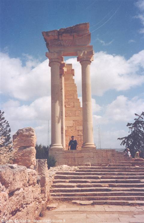 Tourist among the stone columns of the Temple of Apollo under cloudy sky