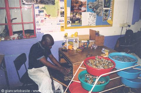 Artisans working in a workshop with colorful bead bowls