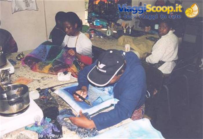 Artisans painting colorful batik fabrics in a Zambian workshop